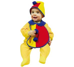 Pieni lapsi istumassa pukeutuneena keltaiseen haalariin sekä kelta-punaiseen ruokalappuun ja hattuun, joita koristavat siniset yksityiskohdat ja tupsut.